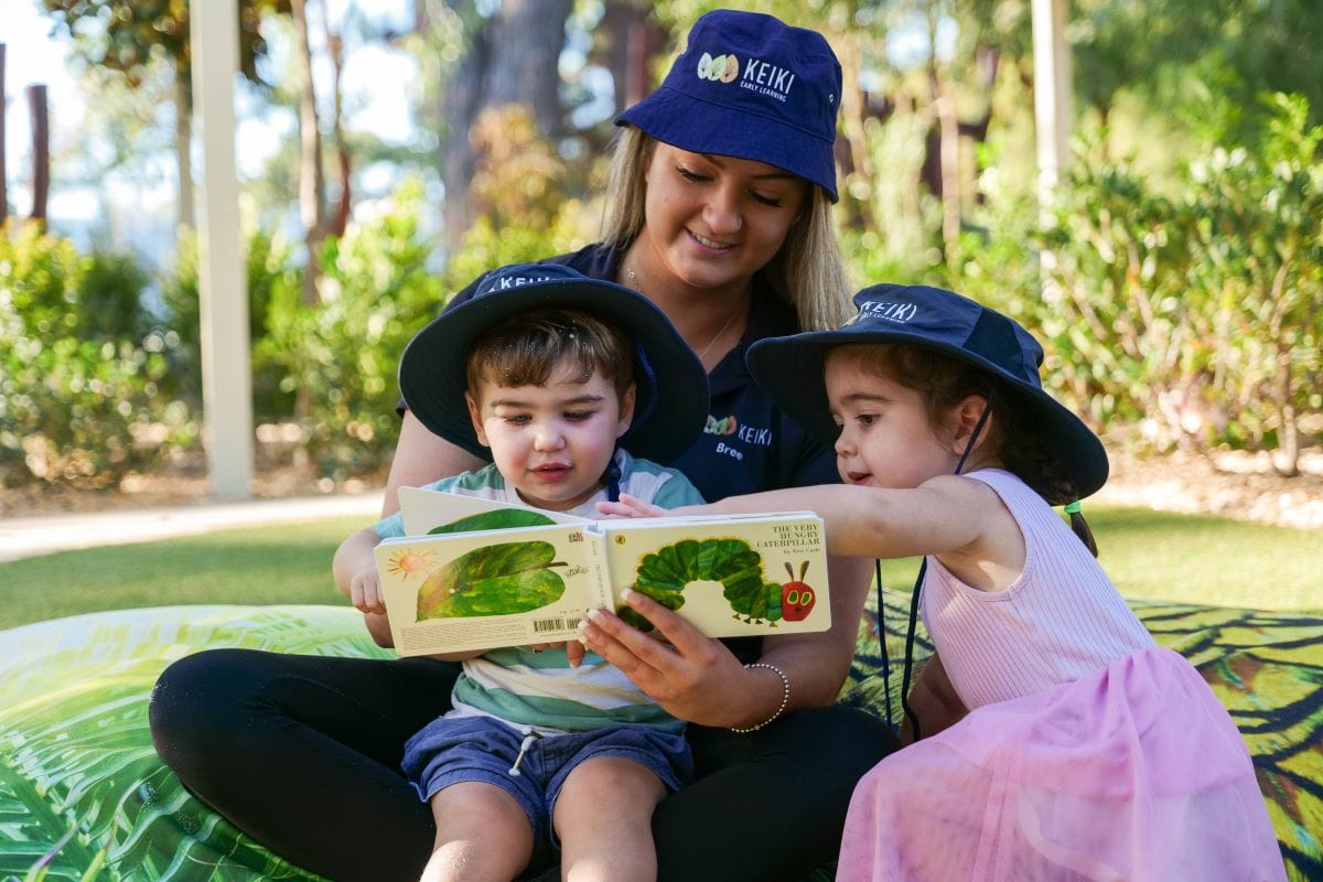 educator reading to young children outdoors